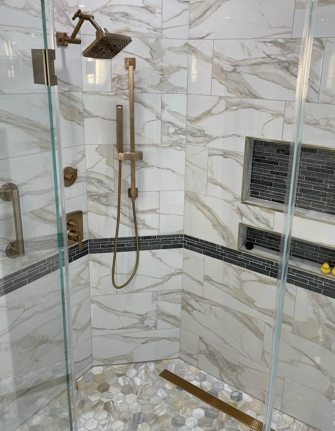 Bathroom Remodel – Shower Interior with Marble Tile, Brass Fixtures, Hexagon Mosaic Floor, and Linear Drain