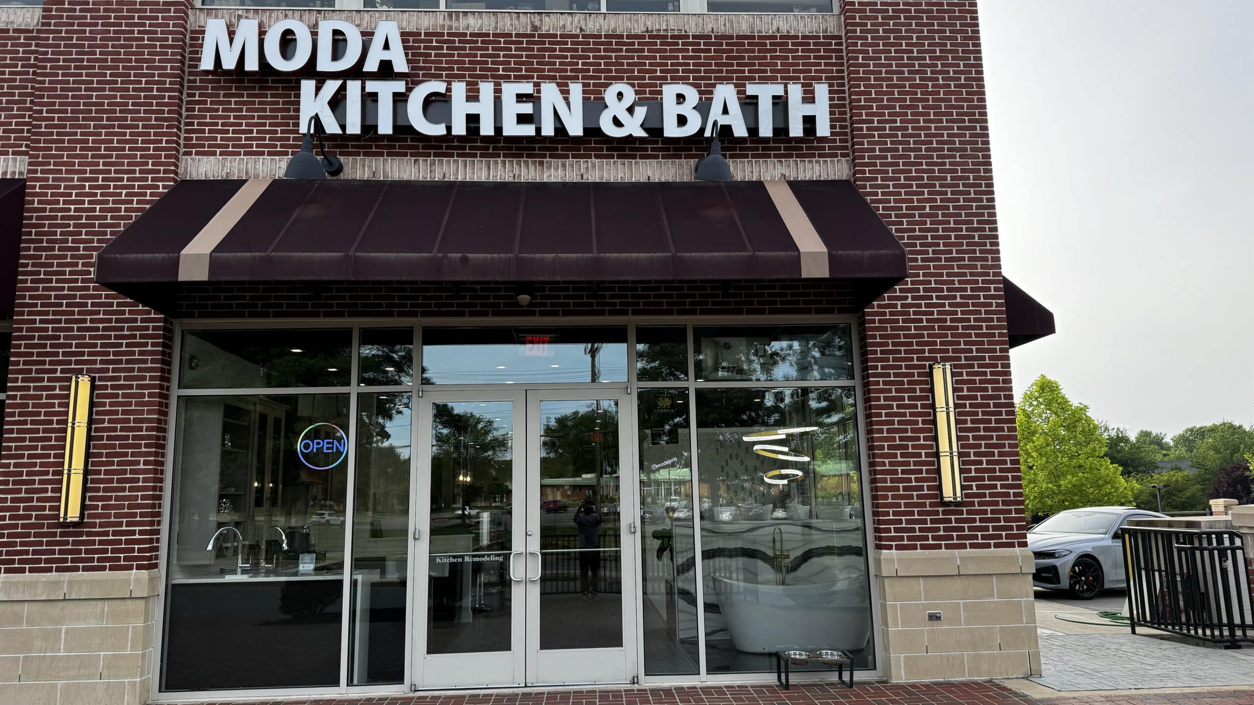 Moda Kitchen and Bath kitchen and bathroom remodeling showroom exterior with brick facade, storefront entrance, and open sign in Northern Virginia